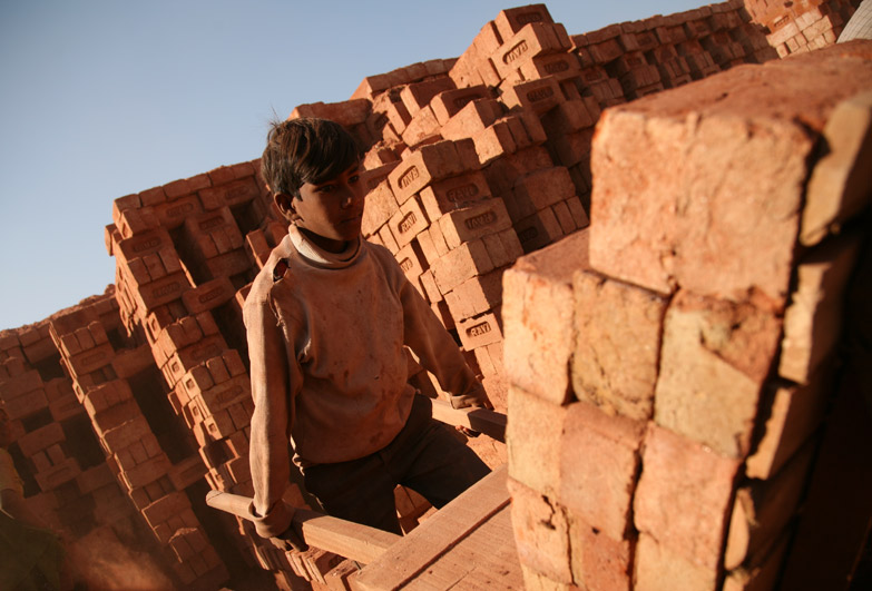 Young boy working in brick kiln in India