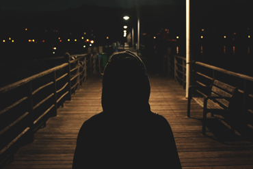 hooded silhouette at night time