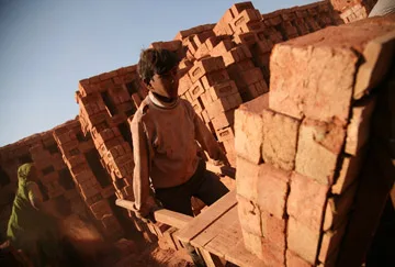 A child works in a brick kiln