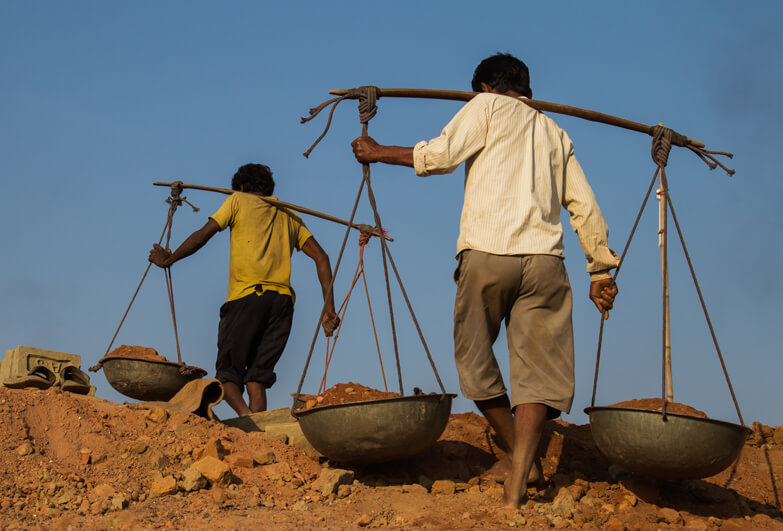 Young boys carrying stones in India