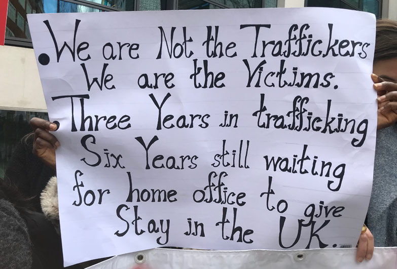 Survivor of slavery holding petitioning sign