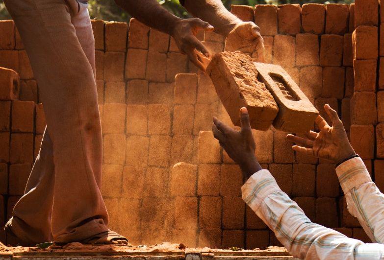 workers passing bricks