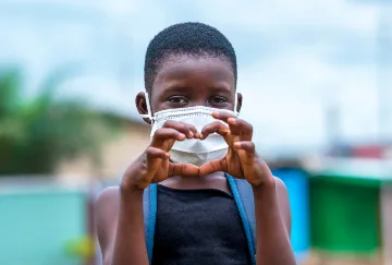 A child makes a heart sign with his hands