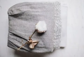 A head of cotton on top of some cotton goods