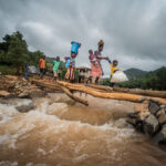 Women cross a gushing river