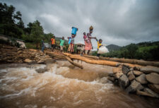 Women cross a gushing river