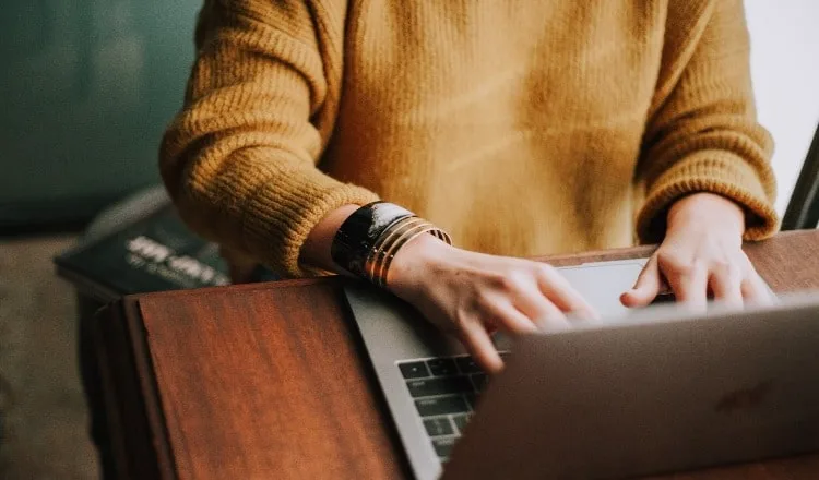 A person types at a laptop