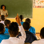 A teacher at the front of a class asks students questions at the vocational school in Tanzania