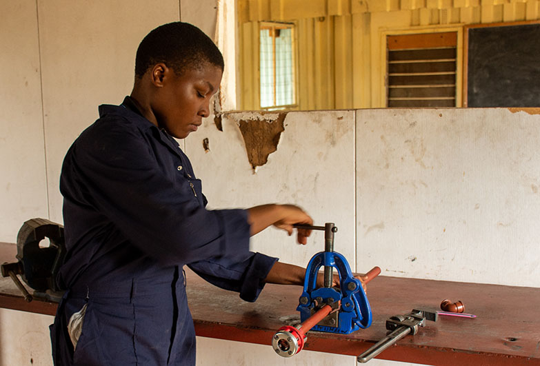 Zalika, a former child domestic worker, training to be a plumber in the vocational workshop