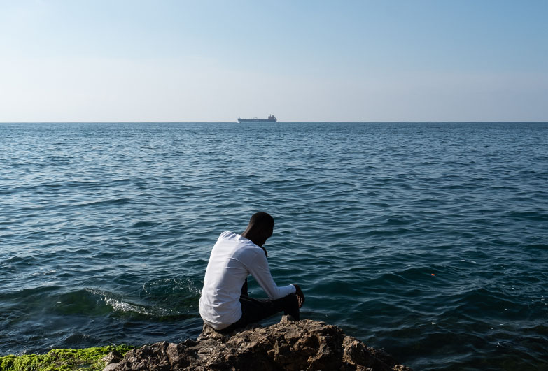 A person sits by the ocean. Credit Jonathon Moore Photography