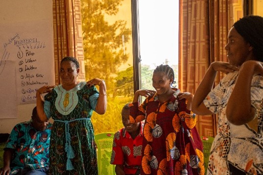 A group of women in bright dresses smiling and dancing