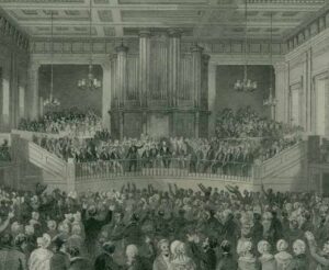 Black and white photo showing hundreds of people packed into a hall for the 1841 conference of slavery abolitionists