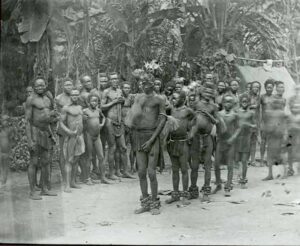 Black and white photo showing a troupe of dancers in the Belgian Congo