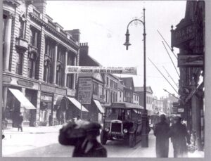 Black and whire photo showing a street scene in Hull, England around 1928. The banner reads Slavery Protest Meeting: Behold, and see if there is any sorrow like unto my sorrow