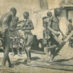 Sepia photo showing a group of enslaved black people working in a yard