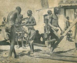 Sepia photo showing a group of enslaved black people working in a yard