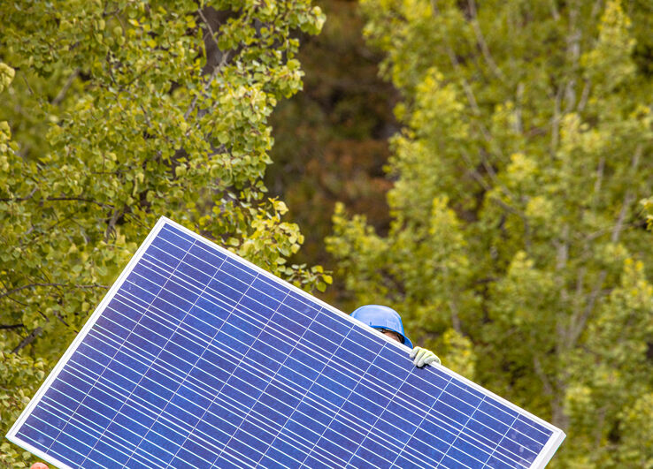 A person carries a solar panel