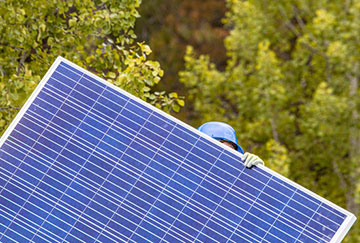 A person carries a solar panel