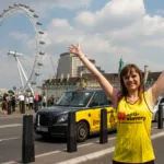 A happy Anti-Slavery International fundraiser cheers outside the London Eye