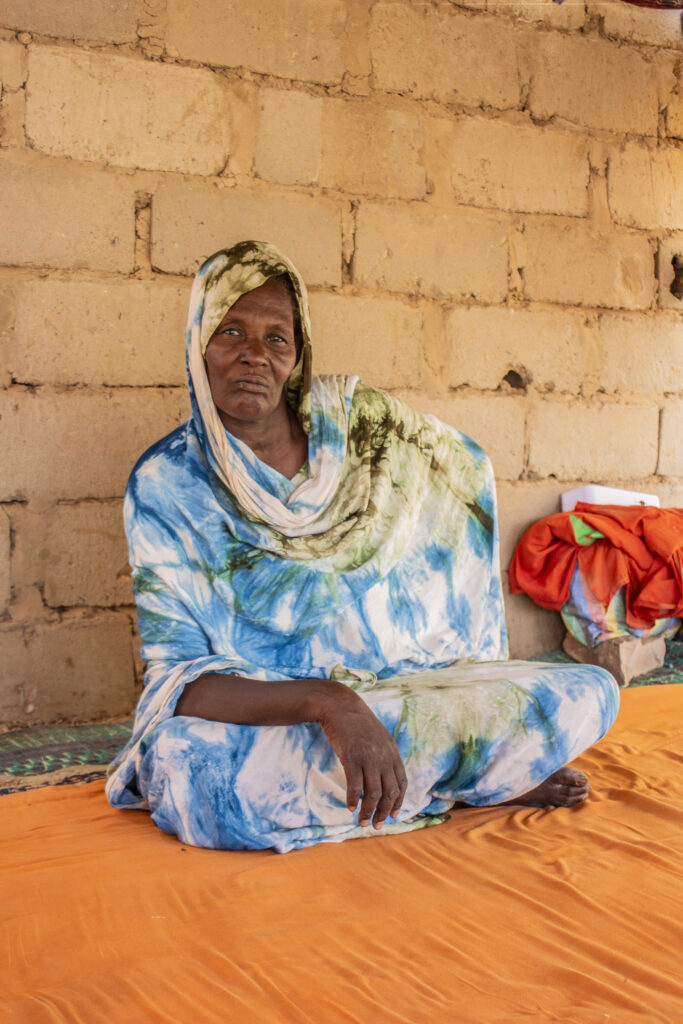 Tahya sits in her home