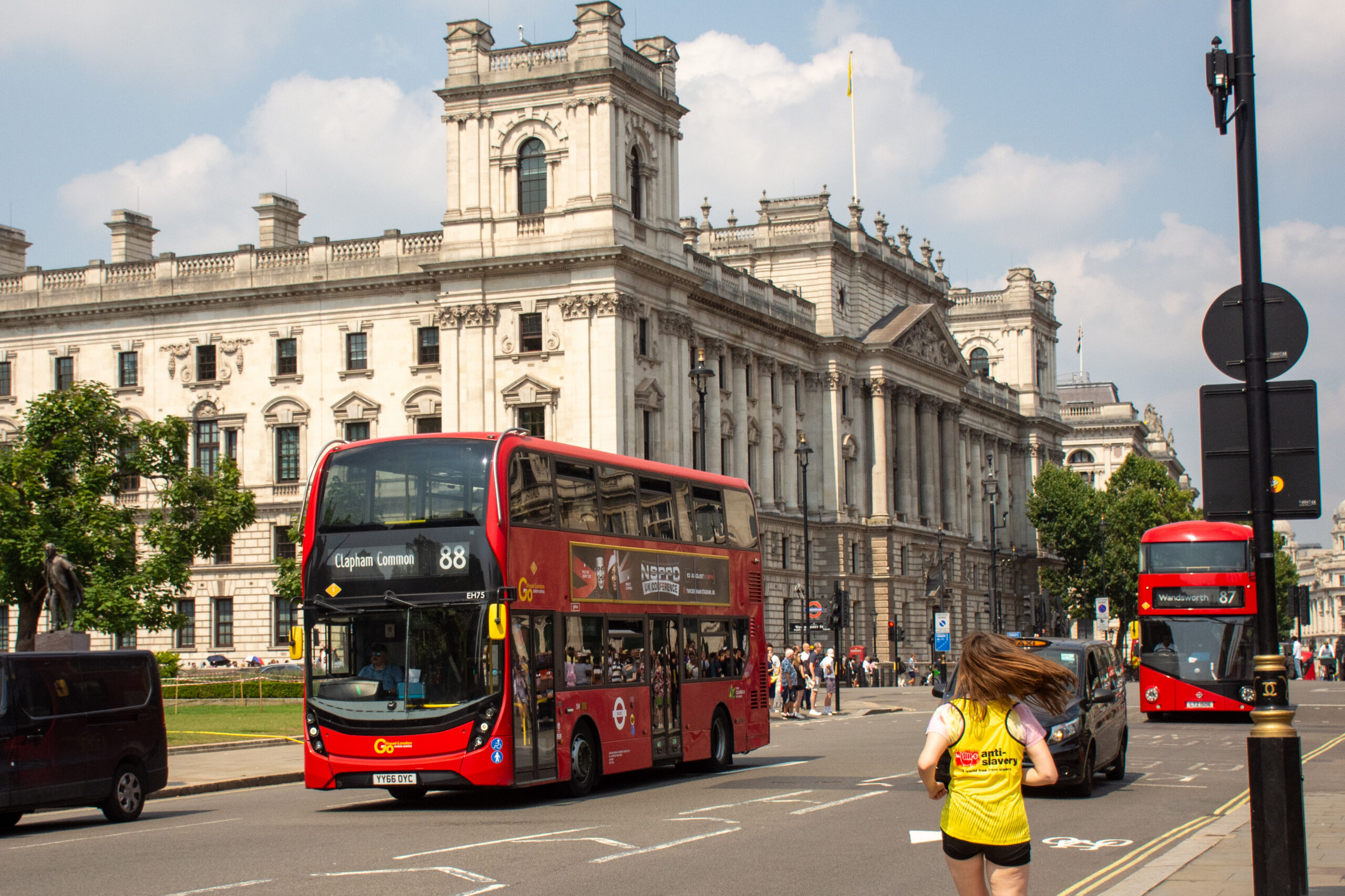 Runner in an Anti-Slavery International vest running past London Landmarks for a marathon.